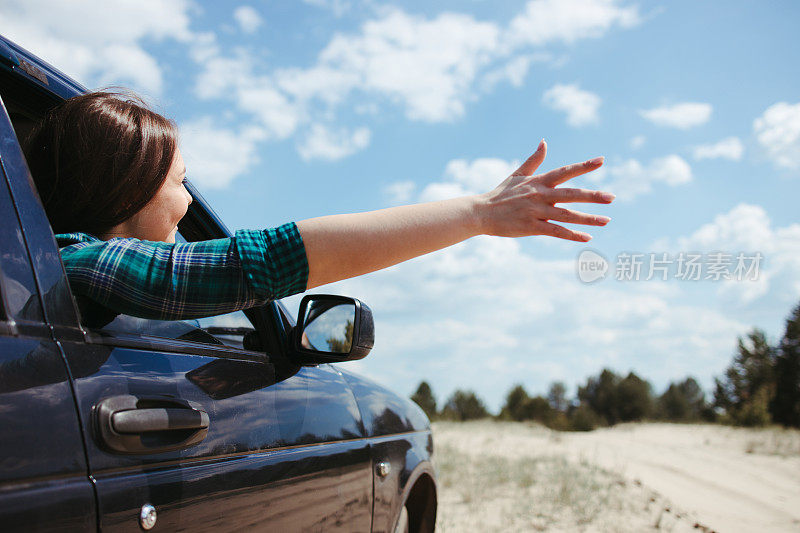 快乐的年轻女子在旅行。汽车之旅
