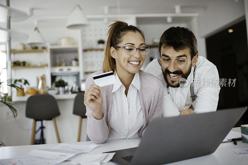 幸福的年轻夫妇支付账单网上电脑应用程序库存照片