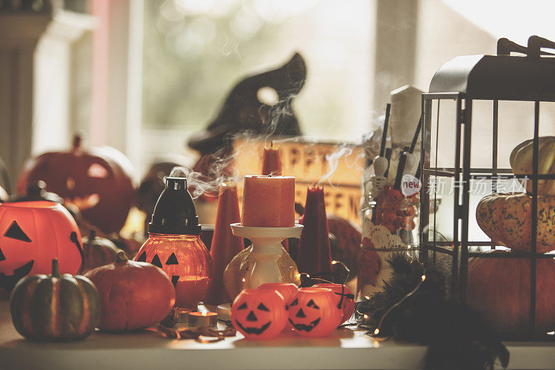 在桌子上扑灭橙色蜡烛和万圣节装饰品的正面视图