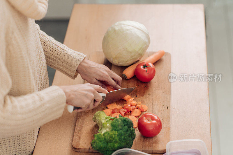 一个面目全非的女人在为她的午餐盒切蔬菜