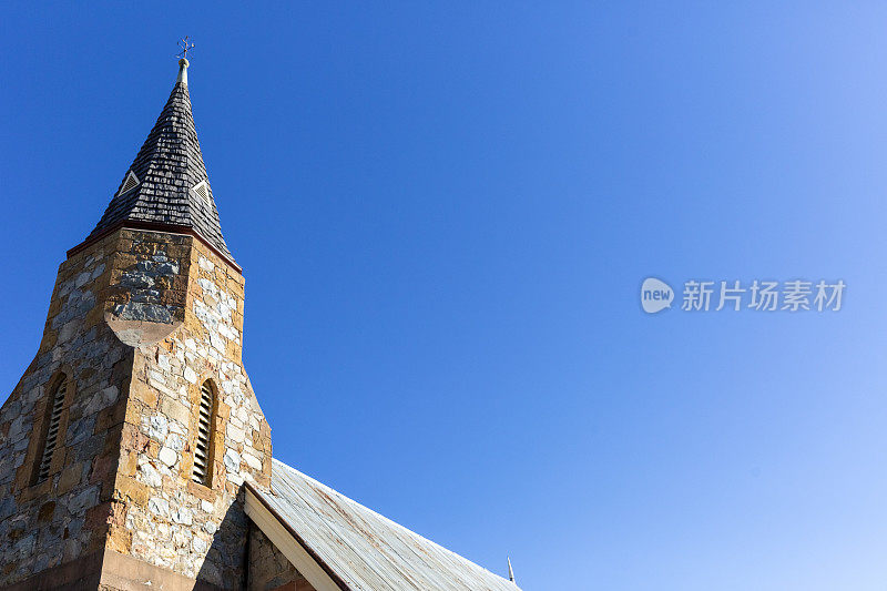 古老的石头教堂塔，蓝天背景与复制空间