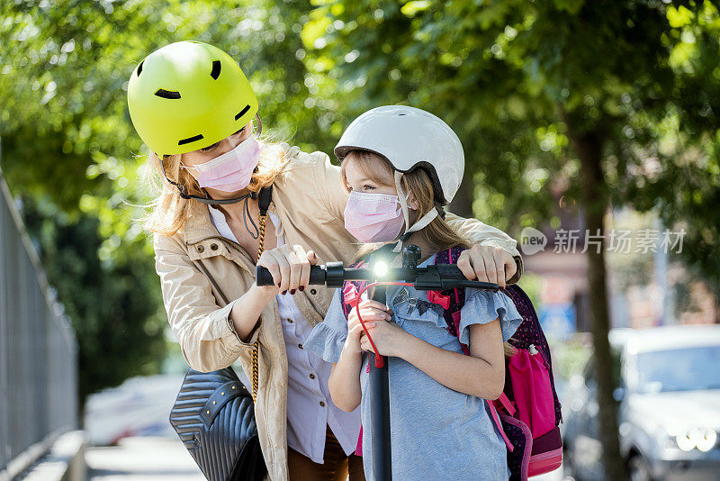 小女孩和妈妈骑电动车到学校
