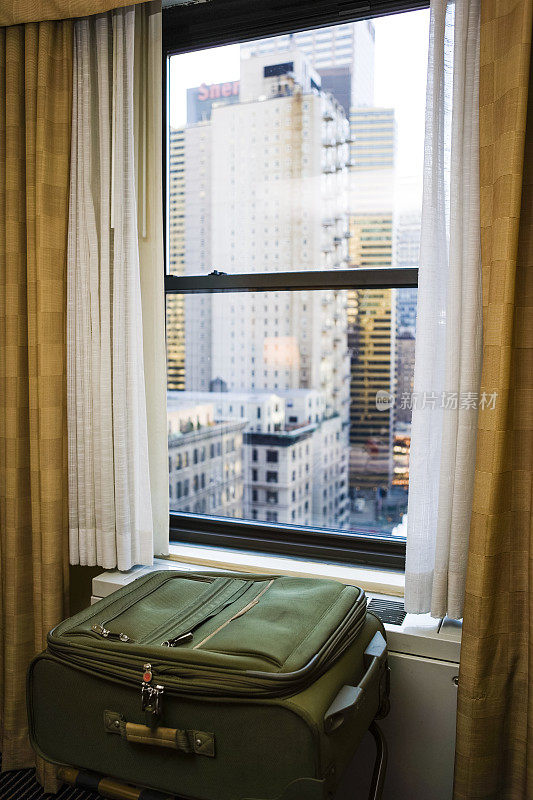 酒店窗边的提箱