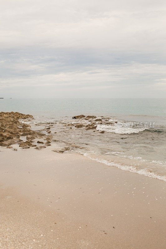 2021年8月，在新冠病毒三角洲变种崛起期间，海浪拍打着佛罗里达州辛格岛的空岩石海滩海岸线