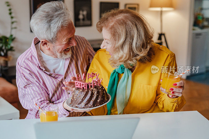 一对老夫妇正在家里通过视频电话庆祝生日