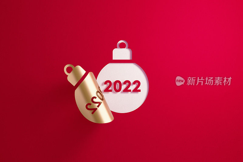 圣诞节概念-金色的小玩意形状折叠揭示2022在白色背景