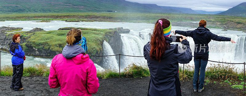 在冰岛北部，游客们在大瀑布上拍照