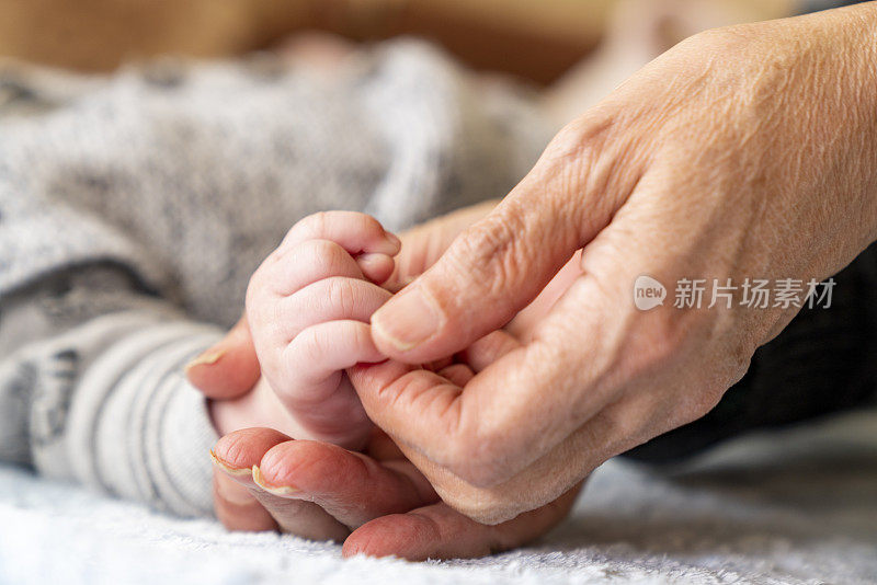 奶奶牵着孩子的手。母亲和孩子的手。家庭的概念