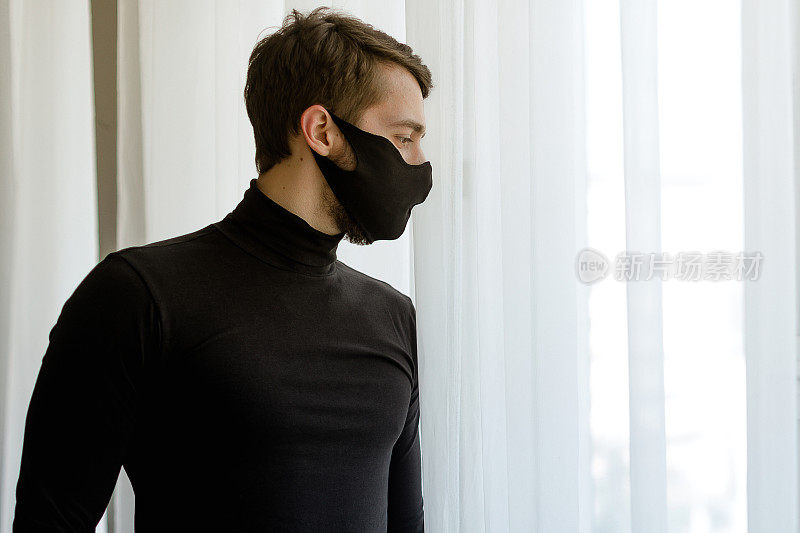 成年男子在室内佩戴可重复使用的医用面部防护口罩的肖像。新冠肺炎疫情后的新常态为经营理念