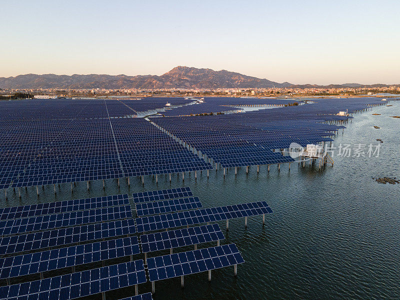 日落时海上太阳能发电厂的鸟瞰图。