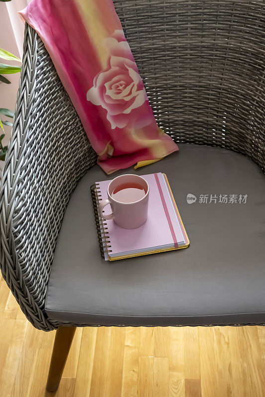 在粉色日记本上放一杯花草茶
