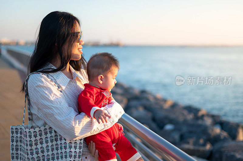 女人和她的小男孩在海边看日落