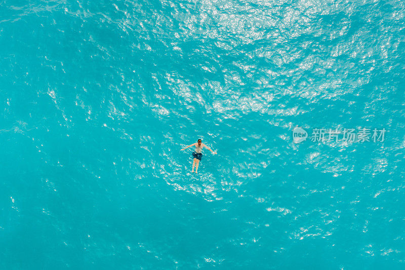 鸟瞰一只雄性在土耳其Oludeniz晶莹湛蓝的海水中游泳