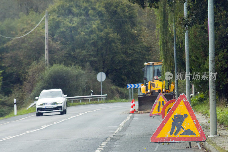 乡村道路前方工程标志、车辆经过、前方危险警告。