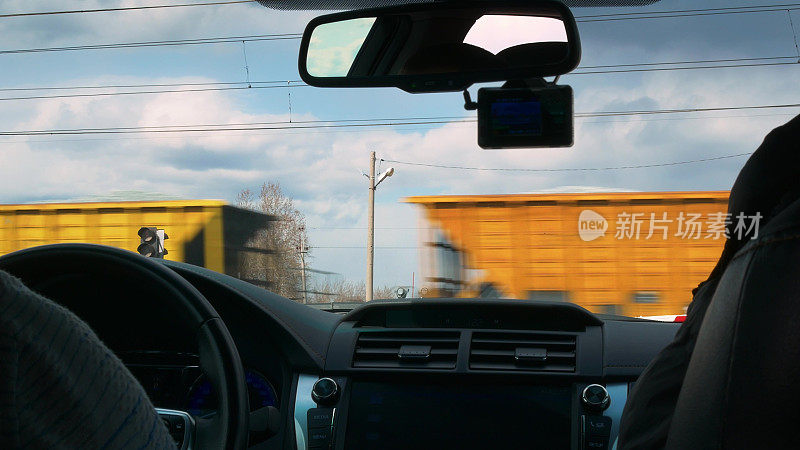 第一人称视角:从沿铁路道口行驶的火车货运车厢的乘客舱的第一人称视角FPV视角的挡风玻璃俯瞰一列货车车厢。