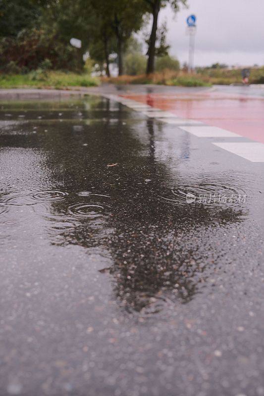 垂直拍摄的雨滴落在德国街道的地面上