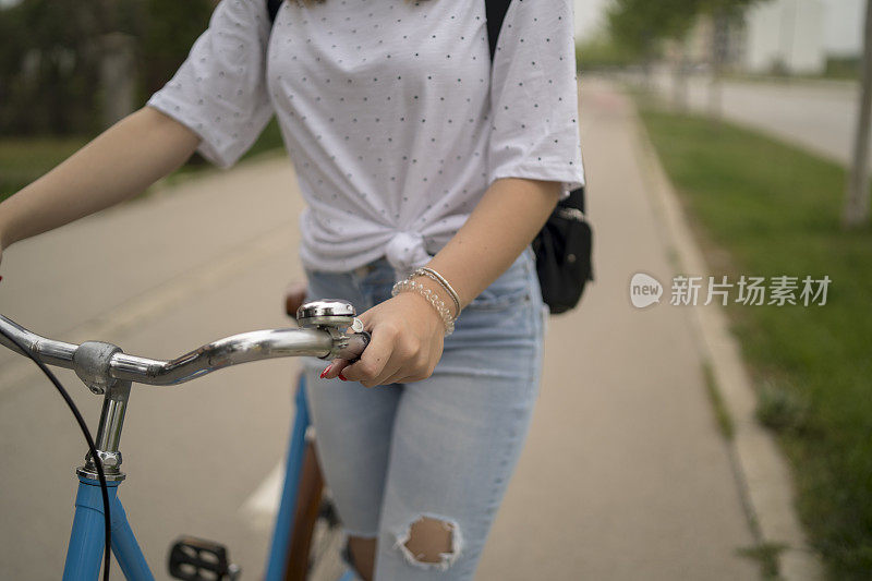 迷人的年轻女子骑着自行车微笑着