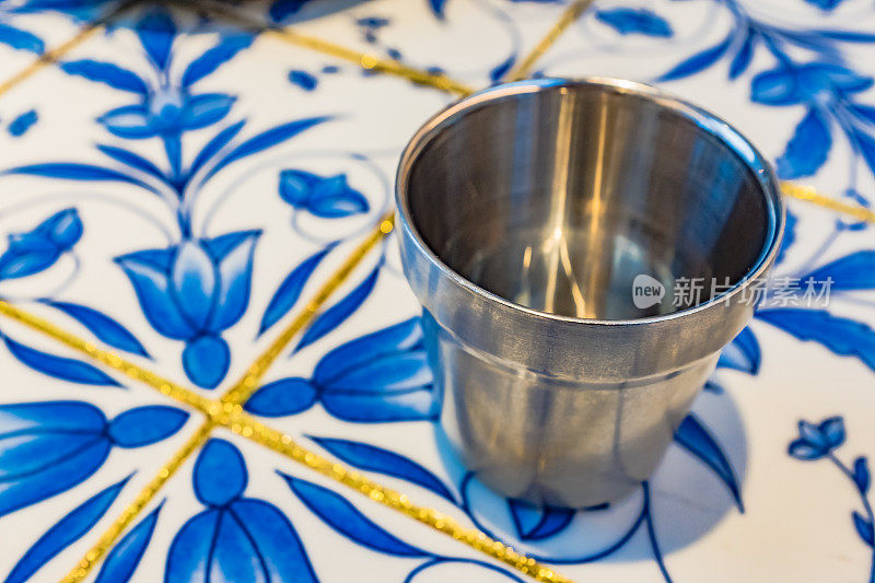 餐厅里的青花瓷桌上放着一个不锈钢杯子