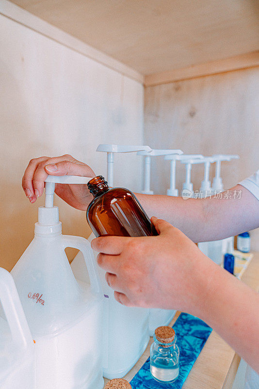 年轻女子的手从瓶子里抽出洗发水，在无塑料零售店做出可持续的选择