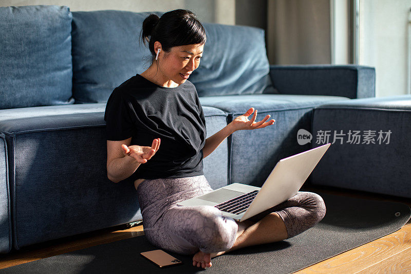 年轻的日本女子在家里锻炼后使用笔记本电脑