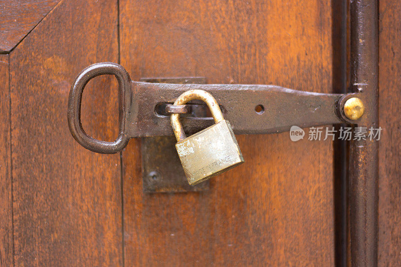 法国:老棕色木门上生锈的锁特写