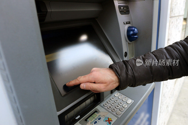 银行客户使用自动柜员机的触摸屏完成交易时的手和手指