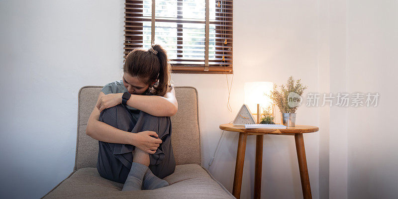 年轻的亚洲女人在卧室里感到悲伤，疲倦和担心，在心理健康方面遭受抑郁症