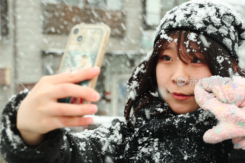 年轻女子在下雪的街道自拍