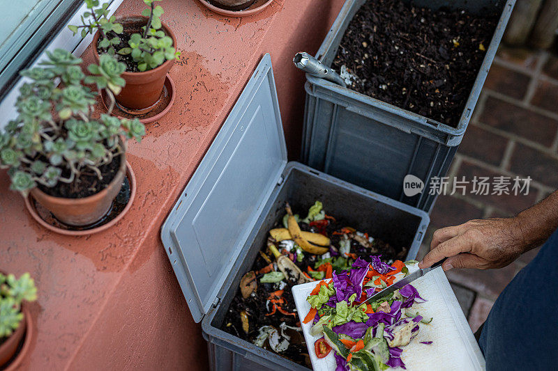 男子在家用堆肥机中堆肥有机残留物