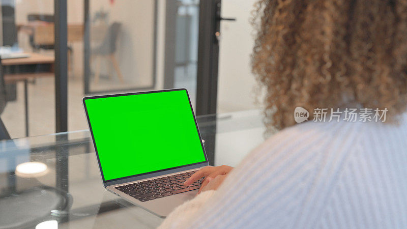使用绿屏笔记本电脑的非洲妇女