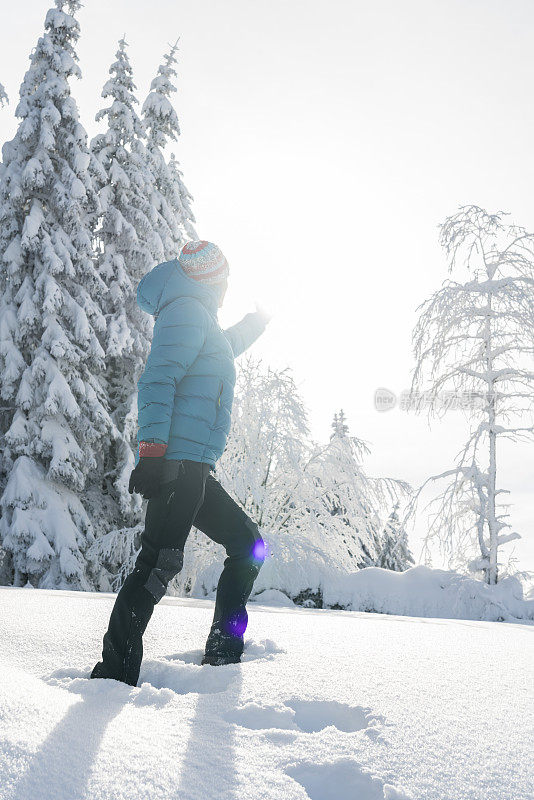 成熟的女人穿着冬装站在雪地里