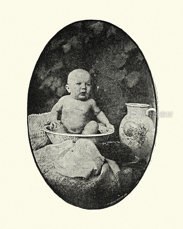 一个婴儿在洗脸盆里的复古照片，维多利亚19世纪