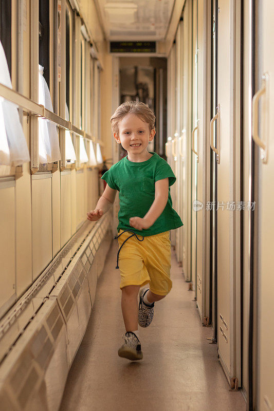 柔焦童子童子快乐地跑在火车车厢里。铁路旅客旅游和儿童休闲概念。
