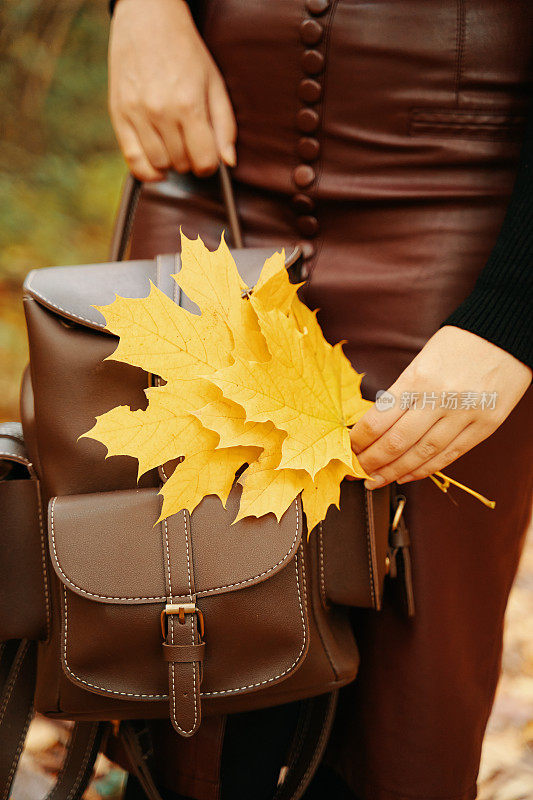 带着背包和树叶的女人。