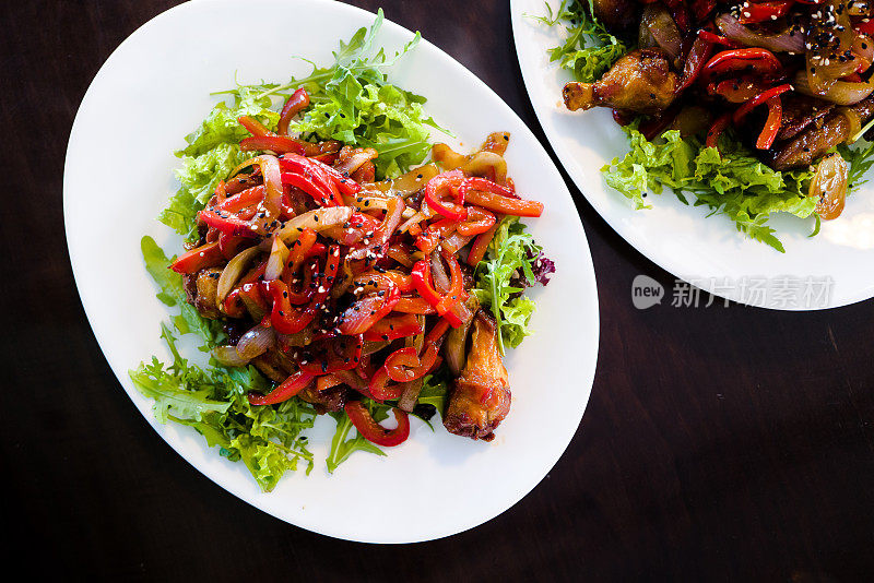 在美食餐厅里，白色盘子里的鸡翅和沙拉