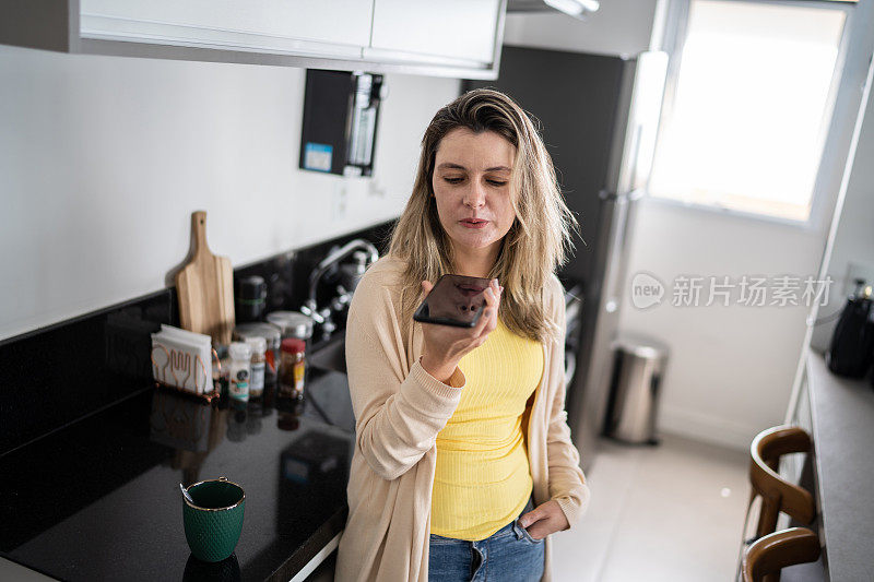 女人在家用智能手机发语音信息