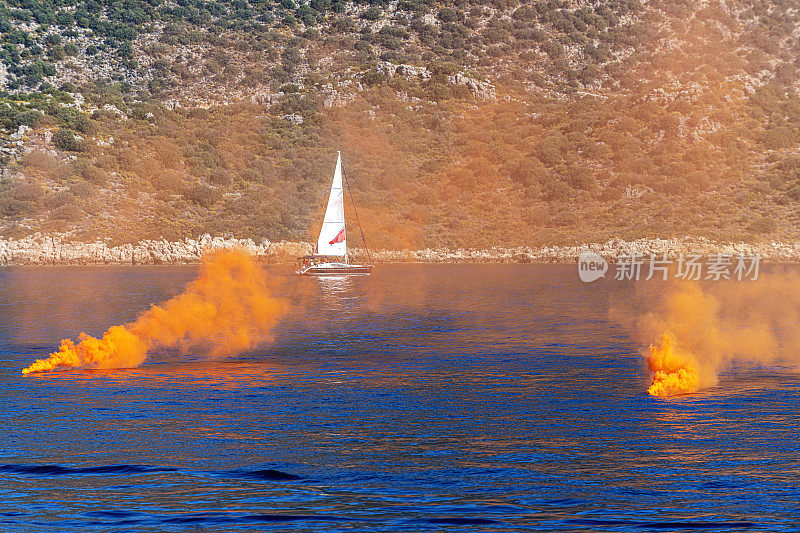 橙色烟雾弹与帆船。遇险信号