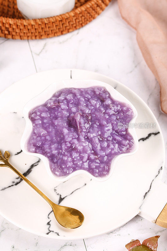 盘子里放着一碗紫薯粥