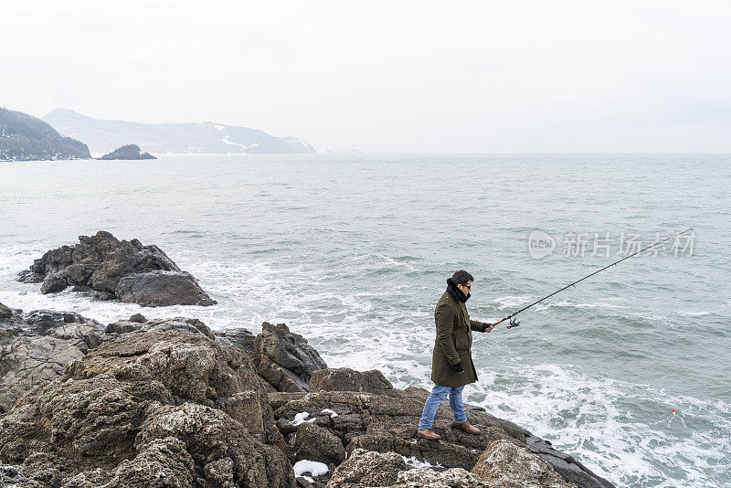 男人在黑海沿岸用钓鱼竿钓鱼