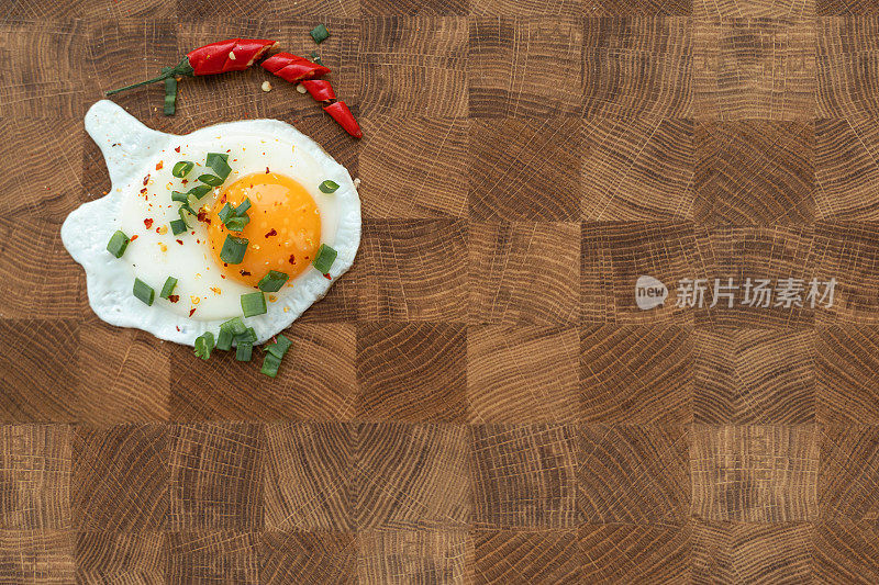 煎鸡蛋，葱花和辣椒放在木板上