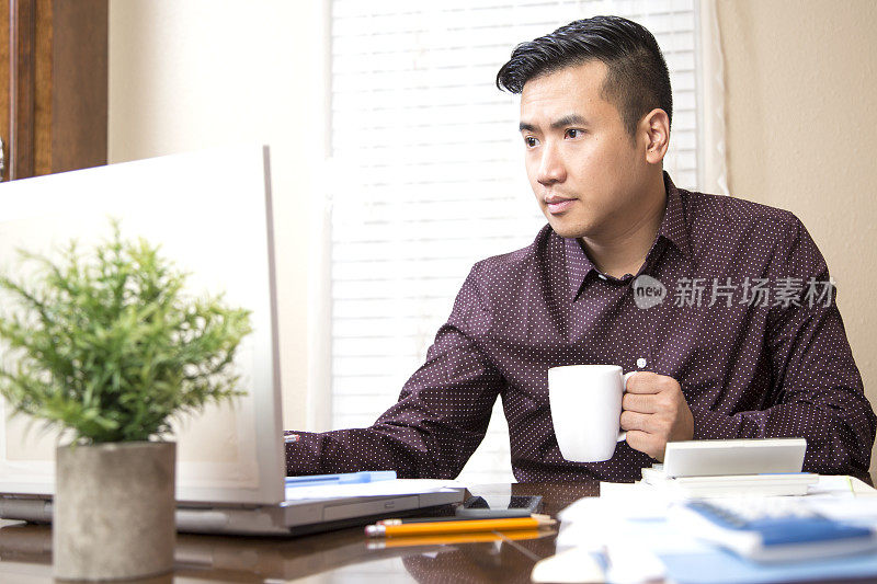 企业家亚洲越南男子工作在一个客户帐户。他一边喝着咖啡，一边用笔记本电脑和计算器帮客户填写税务表格。