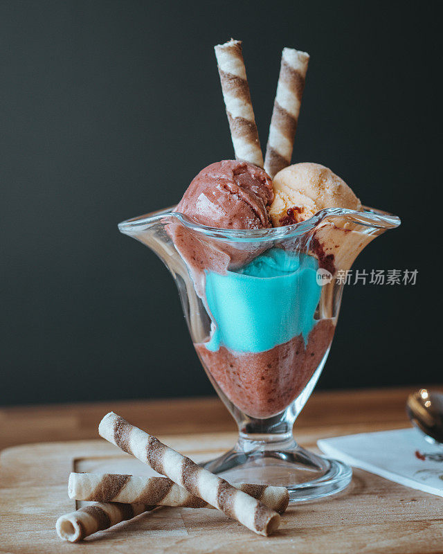 巧克力橙和绿松石冰淇淋品种在一个冰淇淋碗，冰淇淋端在桌子上