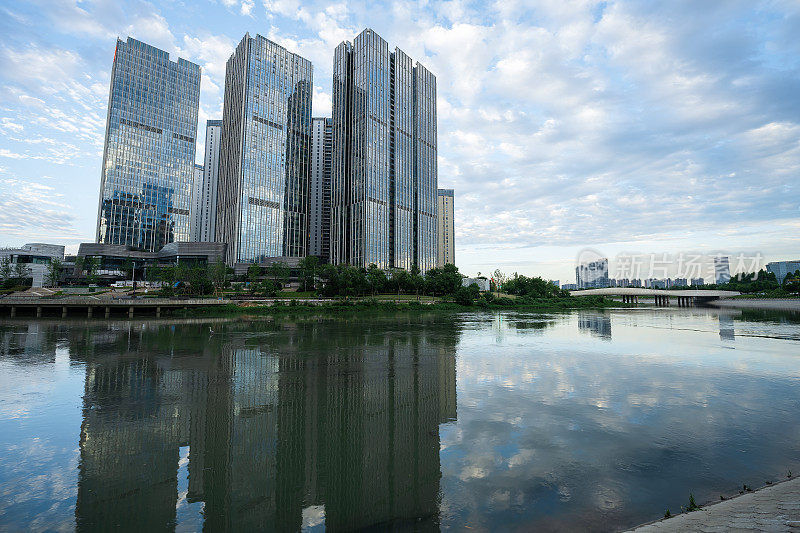 阳光明媚的日子里，沿河有现代化的建筑和桥梁