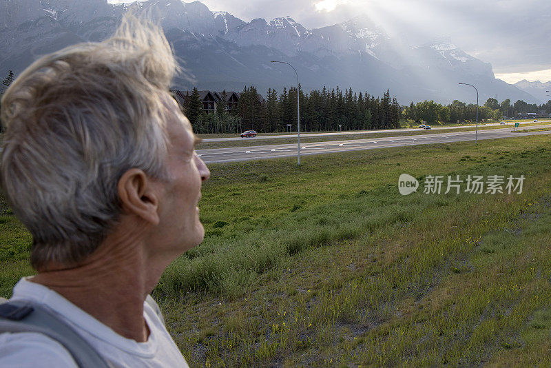 一名老人在山上铺设的小路上徒步旅行