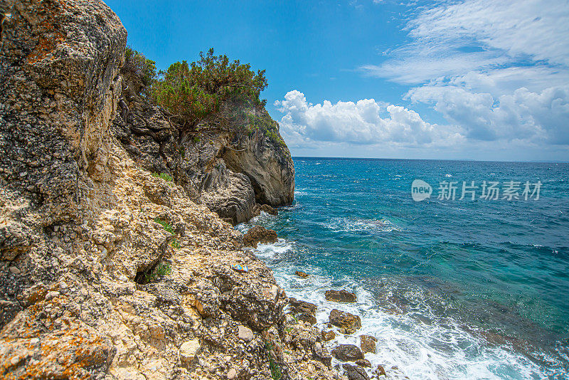 奇特的海滩附近帕尔加与大岩石在蓝色的大海，在松树林。地平线和蓝天的背景视图