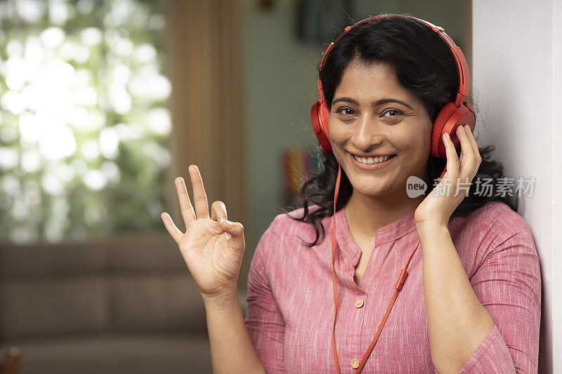 印度女人在家听音乐股票照片