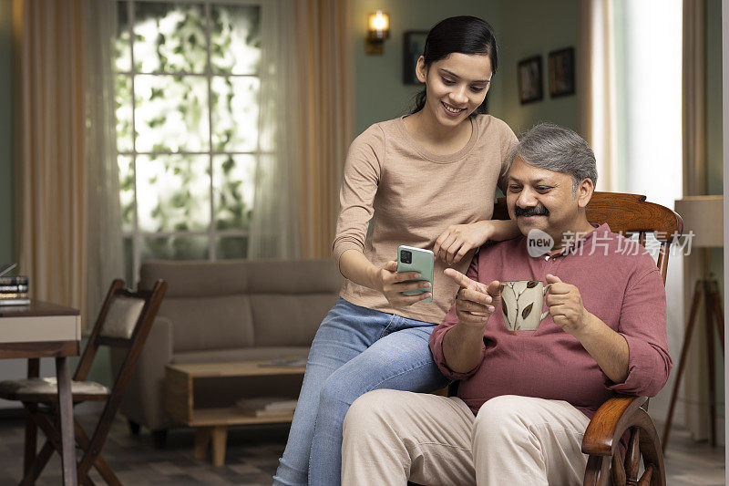 女儿和父亲一起在家里拍股票照片