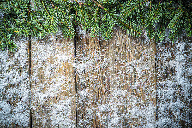 圣诞冬季雪和真正的杉树树枝背景上乡村木板背景