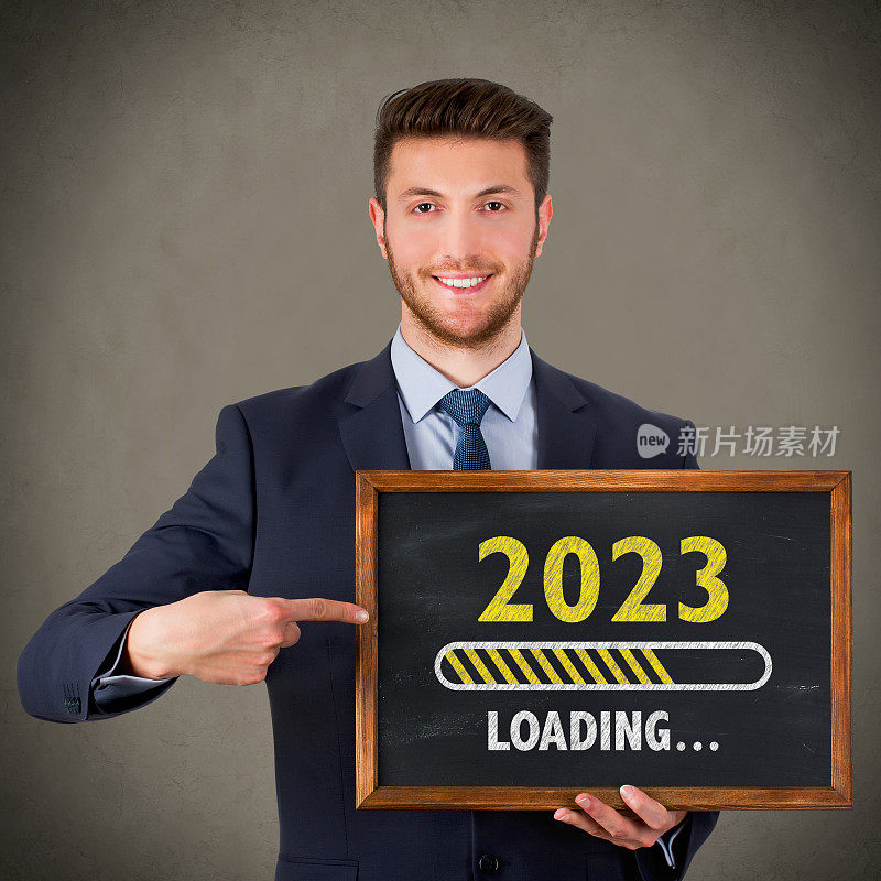 在黑板背景上加载2023年新年的商人绘图