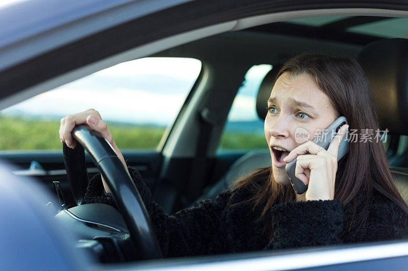 心不在焉的女人一边开车一边打电话。